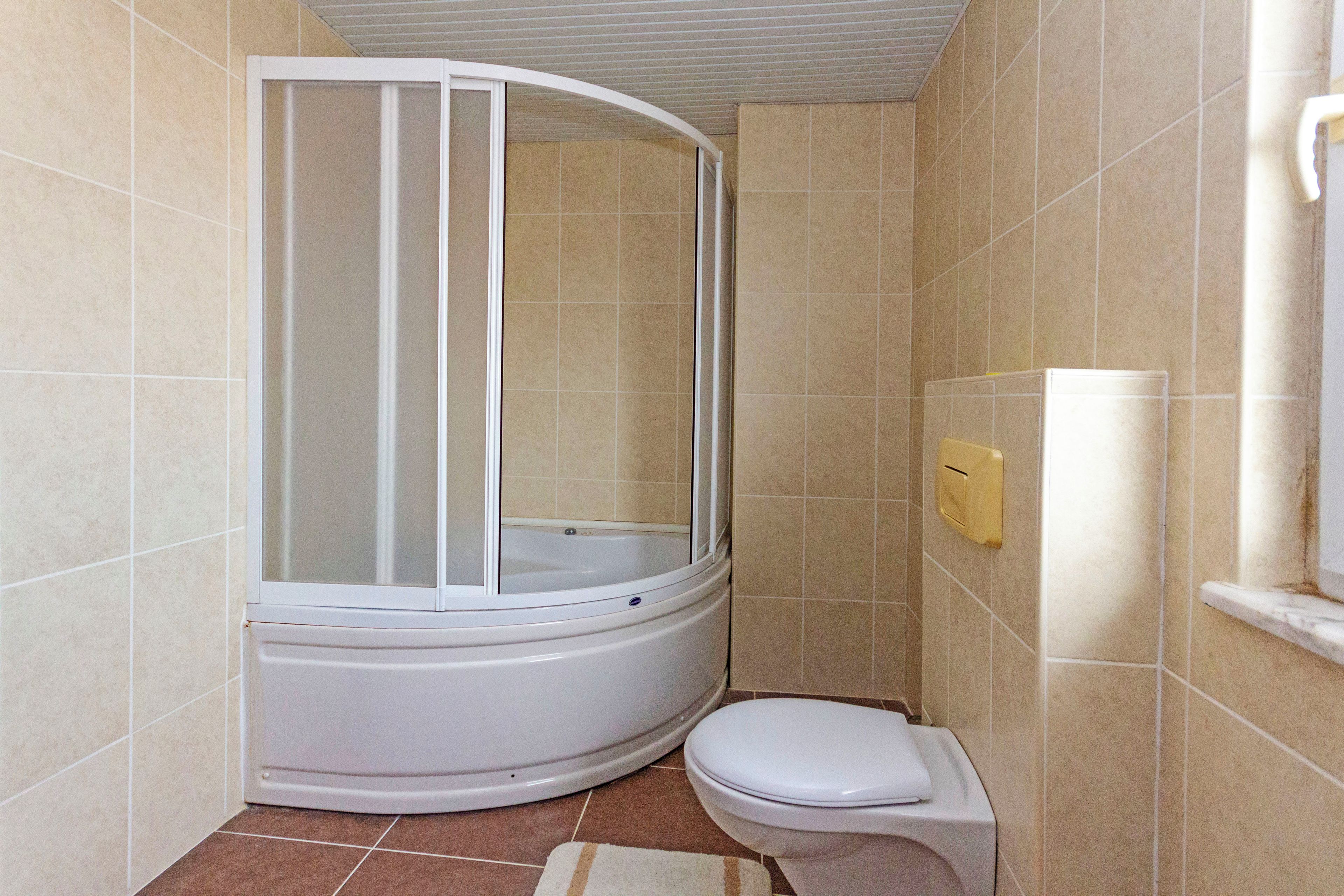 A bathroom with a shower enclosure, toilet, and a towel rack.