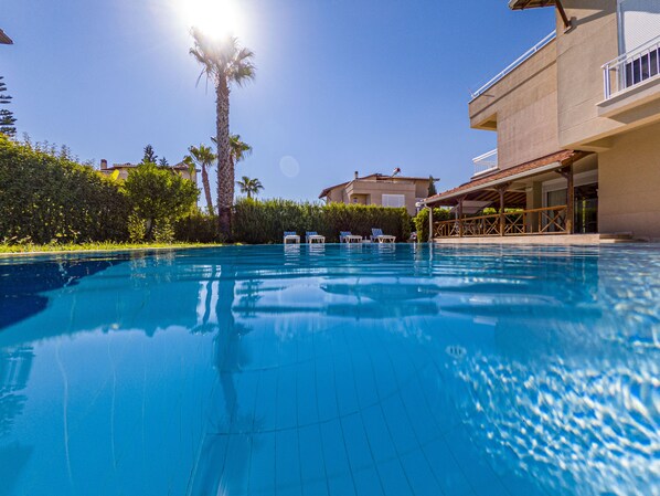 Piscine extérieure, parasols de plage, chaises longues