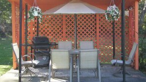 A covered outdoor seating area with a sign that reads "ENJOY YOUR STAY WITH US." - The New Elgin Motel (Saint Thomas)