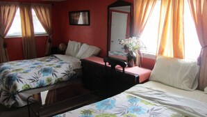 A bedroom with two beds, a dresser, a mirror, and a window with curtains. - The New Elgin Motel (Saint Thomas)