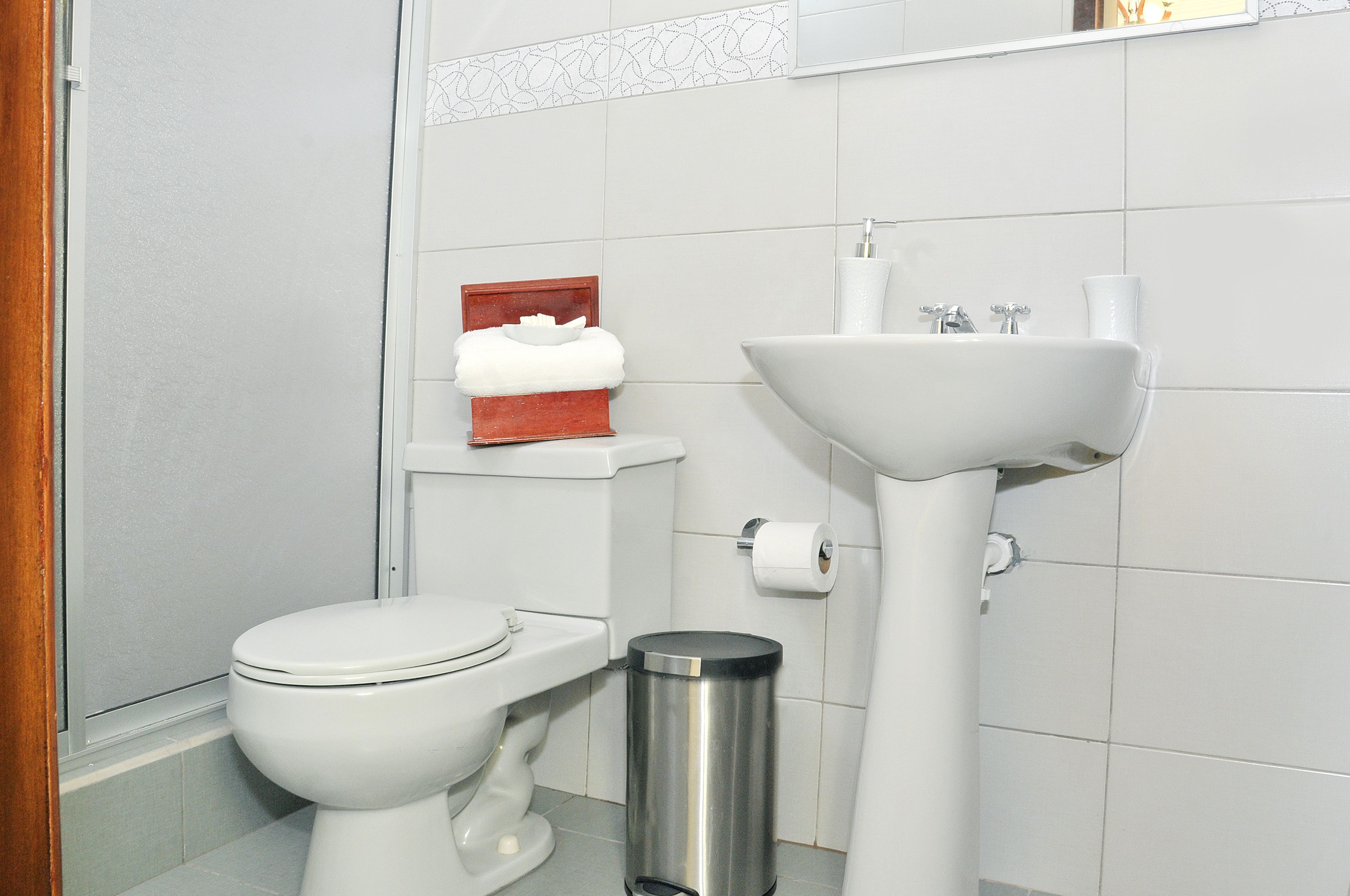 Ein Badezimmer mit Toilette, Waschbecken und Mülleimer.