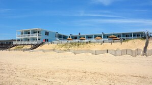 A beachfront property with a multi-level structure, including a balcony and a staircase leading to the beach. - Ocean Surf Resort (Montauk)