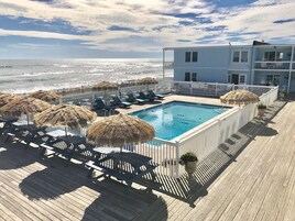 Una piscina al aire libre de temporada, sombrillas