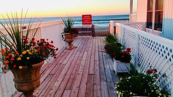 A wooden deck with potted plants and a sign indicating swimming is not allowed.