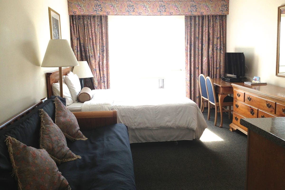 Desk, laptop workspace, blackout drapes, iron/ironing board