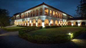 A large, multi-story building with a symmetrical facade, featuring numerous arched windows and balconies. - Sanctum Inle Resort (Nyaungshwe)