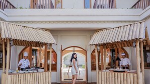 A restaurant with a wooden deck and bamboo canopies. - Sanctum Inle Resort (Nyaungshwe)