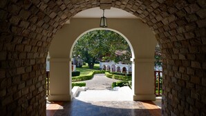 An arched pathway leading to a building with a tiled floor and a hanging lantern. - Sanctum Inle Resort (Nyaungshwe)
