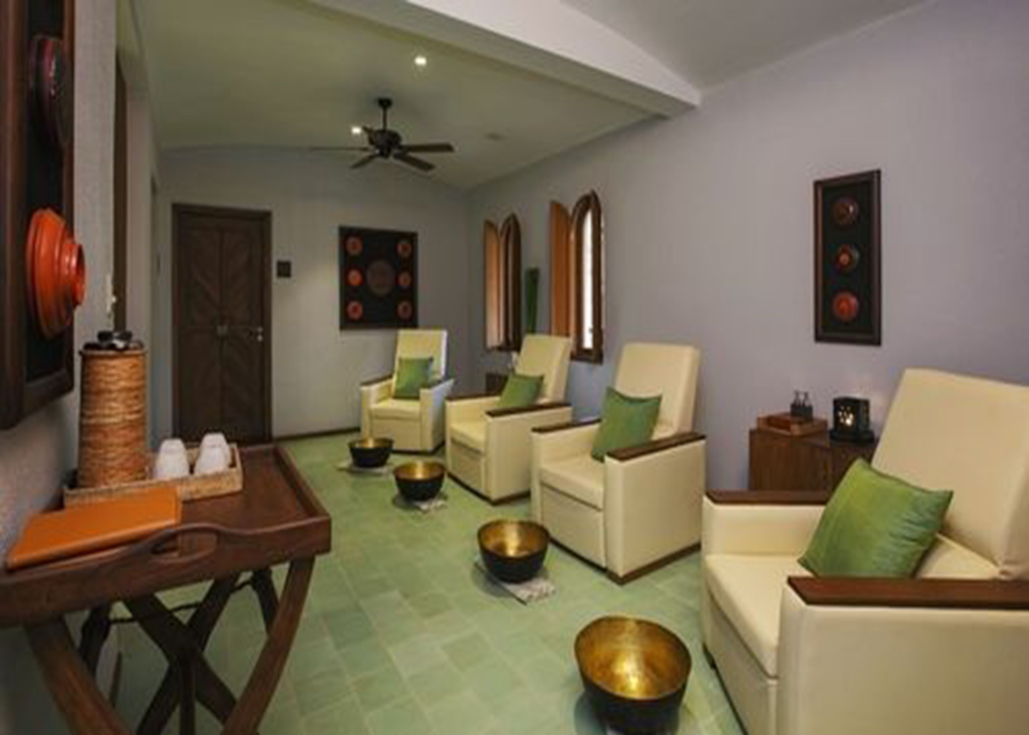 Una sala de estar con sofá, sillones, una mesa de centro y cuencos decorativos.