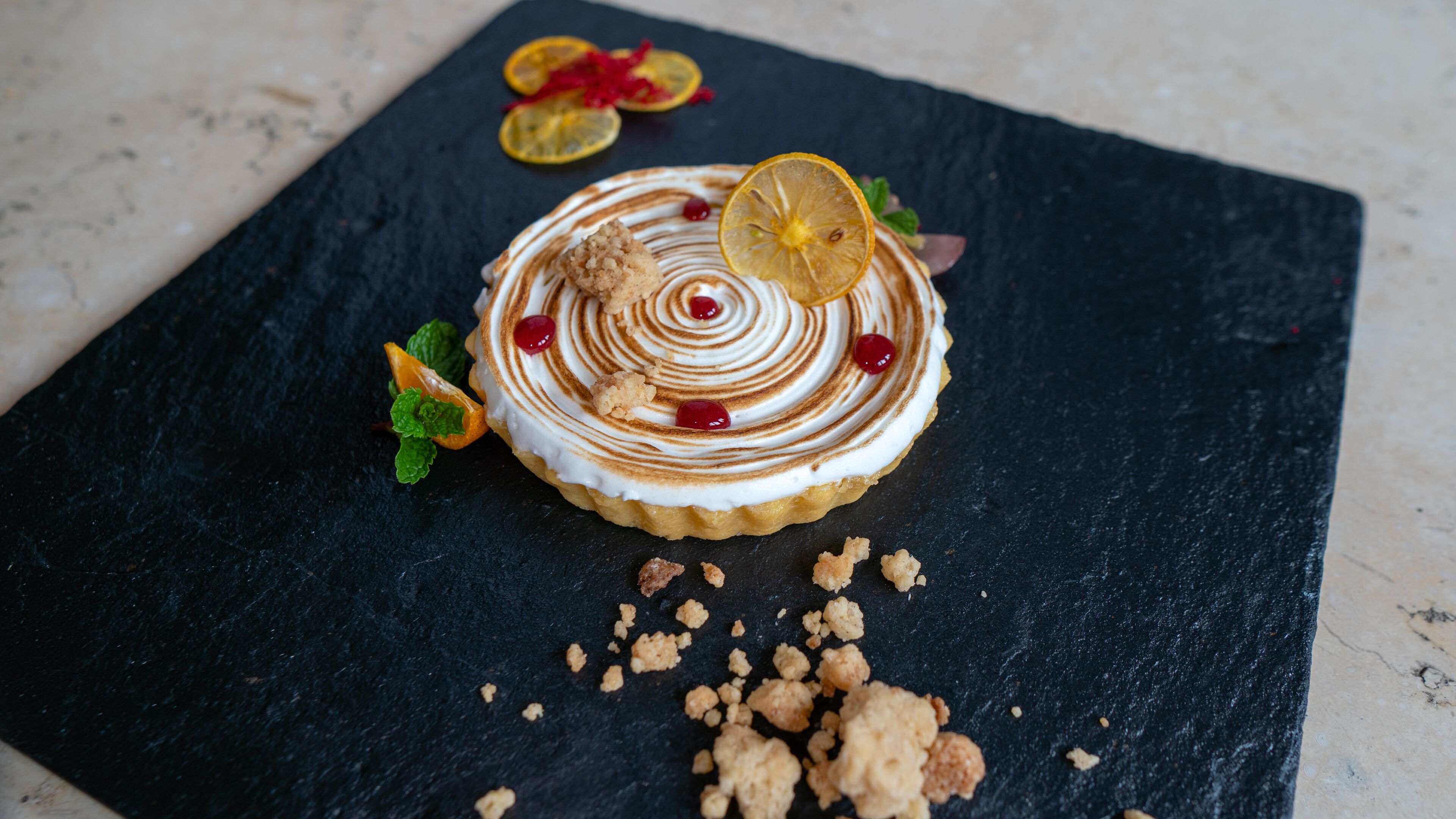 Dessert auf einer Schieferplatte vor dunklem Hintergrund.