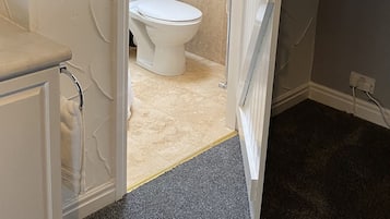 Ein Badezimmer mit Toilette, Dusche und Handtuchhalter.