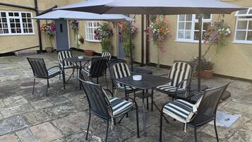 A patio area with outdoor seating and hanging flower baskets.