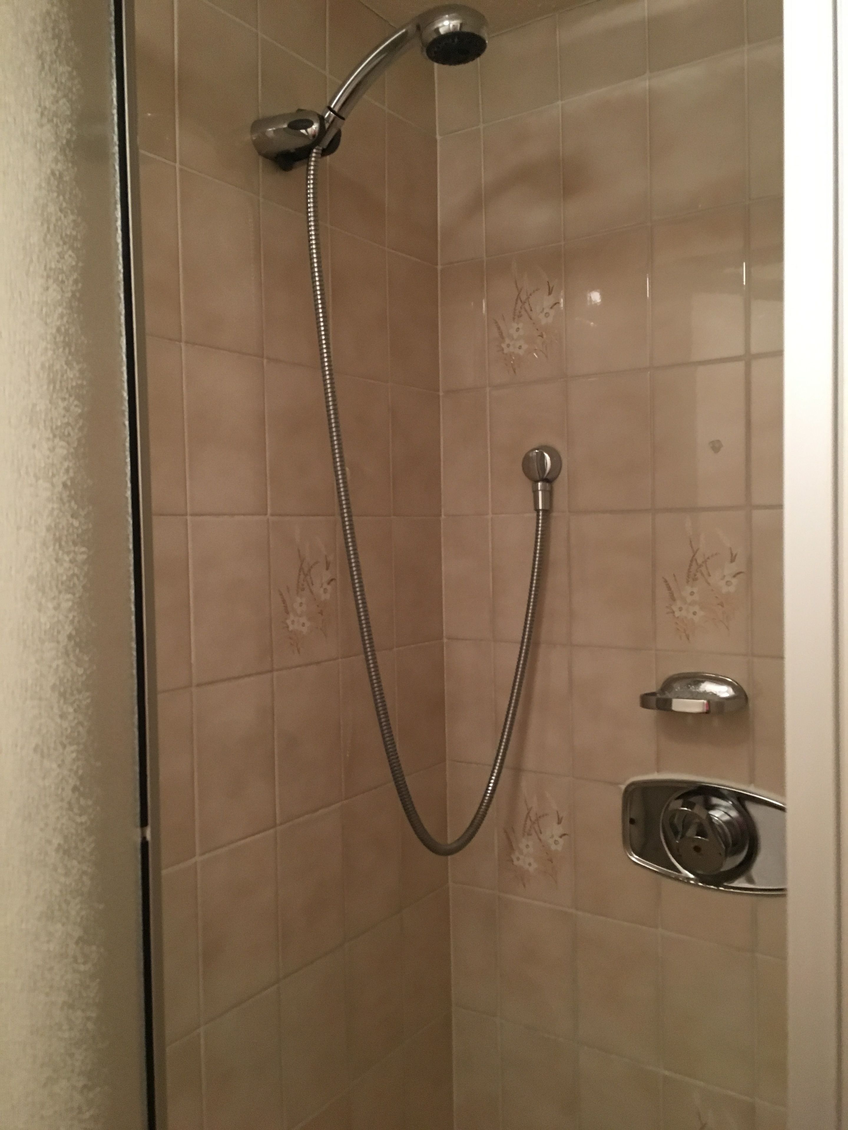 A shower with a handheld showerhead and a fixed showerhead.