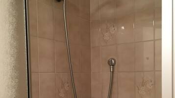 A shower with a handheld showerhead and a fixed showerhead.