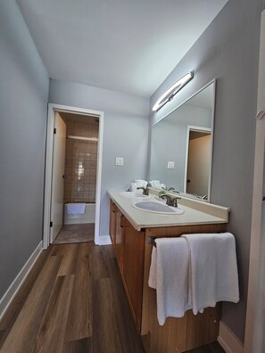A modern bathroom with a wooden vanity, two sinks, and a large mirror.