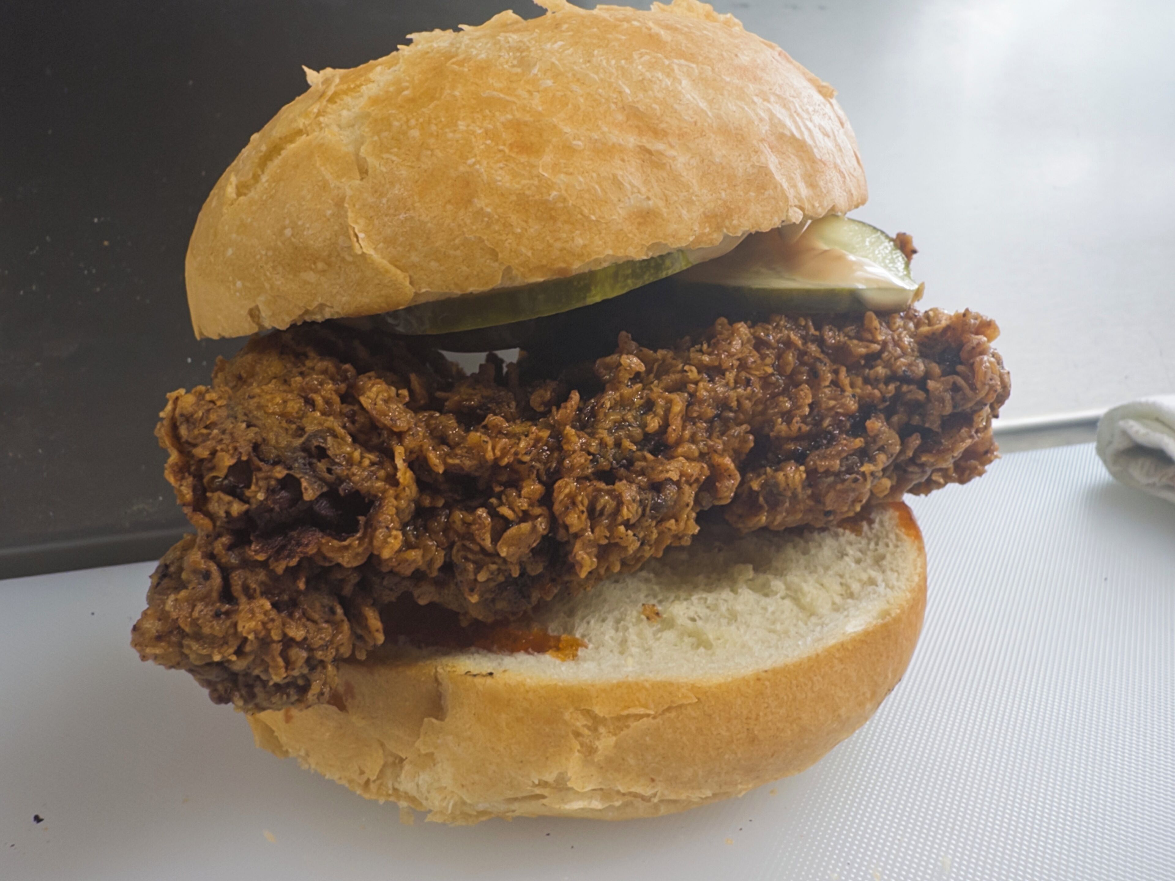 Un sándwich con pan, carne y pepinillo.