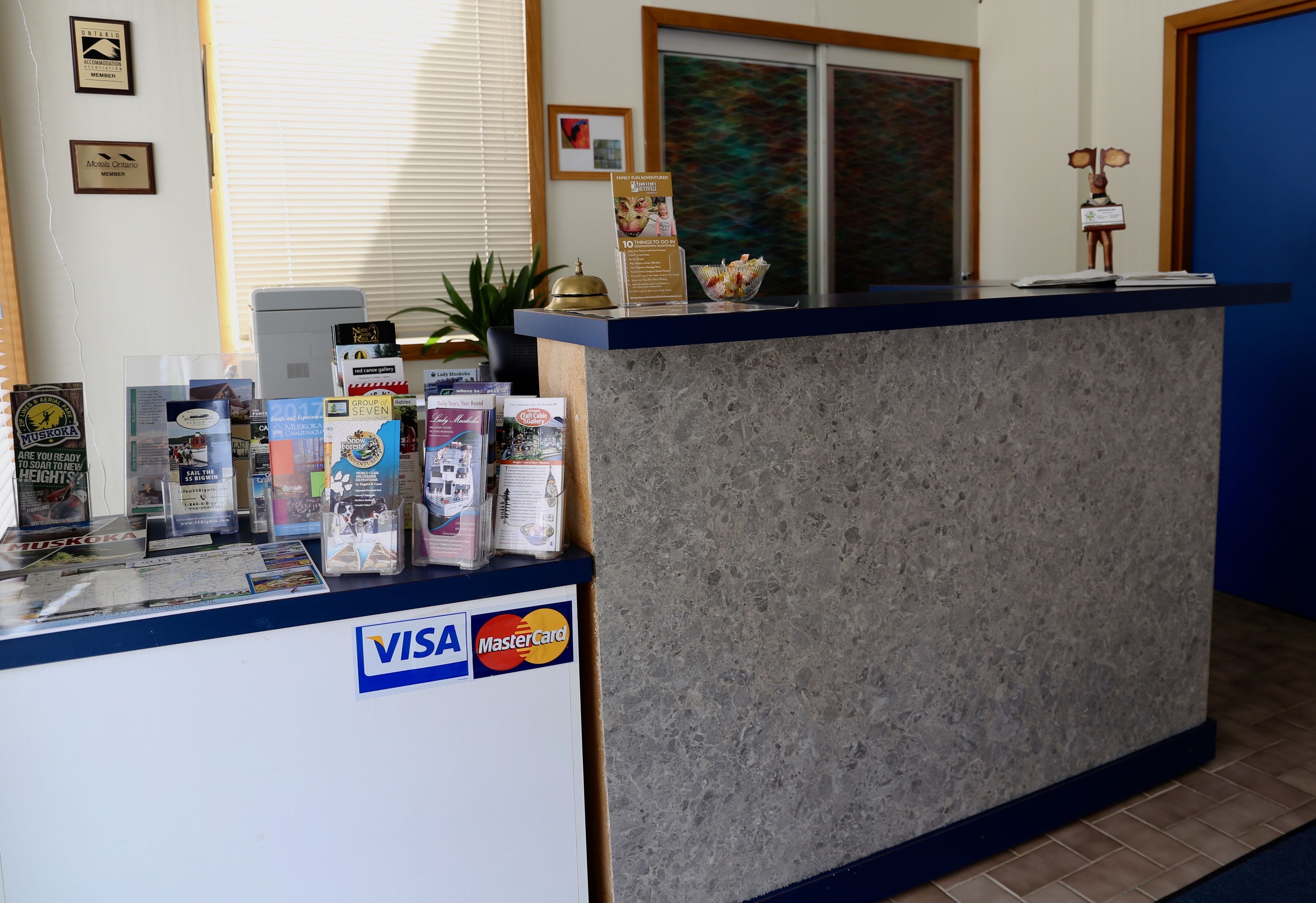 Una reception con il logo Visa e MasterCard, brochure e un piccolo oggetto decorativo.