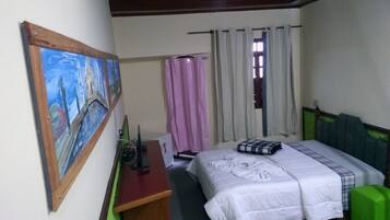 A bedroom with a bed, a desk, a chair, a painting, and a window with curtains.