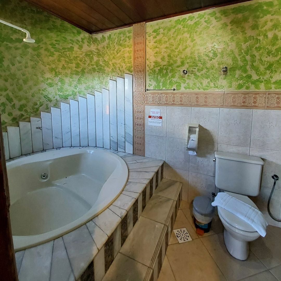 Un baño con una bañera grande, un inodoro y una ducha.