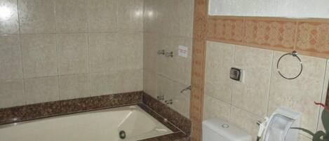 Ein Badezimmer mit Badewanne, Toilette und Handtrockner.