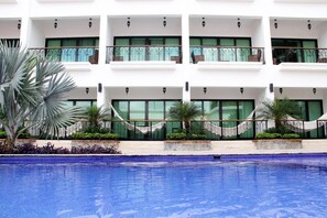 Una piscina al aire libre, camas de piscina gratis, sombrillas