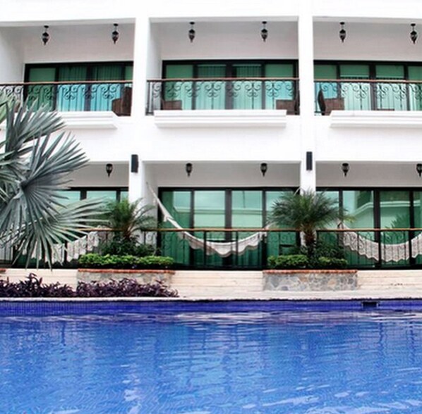 Una piscina al aire libre, camas de piscina gratis, sombrillas