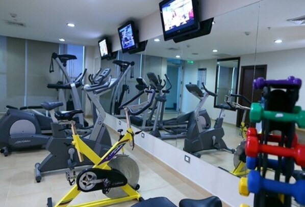 A gym with various exercise equipment including treadmills, stationary bikes, and weight machines. - Hotel Gran David (Santiago)