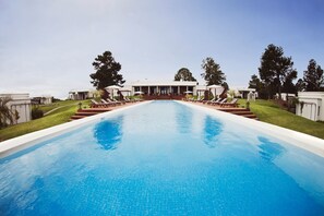 Una piscina al aire libre, tumbonas