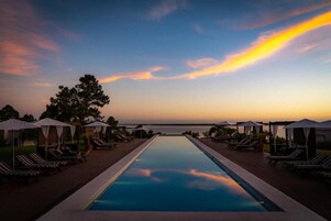 Una piscina al aire libre, sillones reclinables de piscina