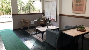Une pièce comprenant un coin repas, un coin salon et une grande fenêtre donnant sur un paysage verdoyant.