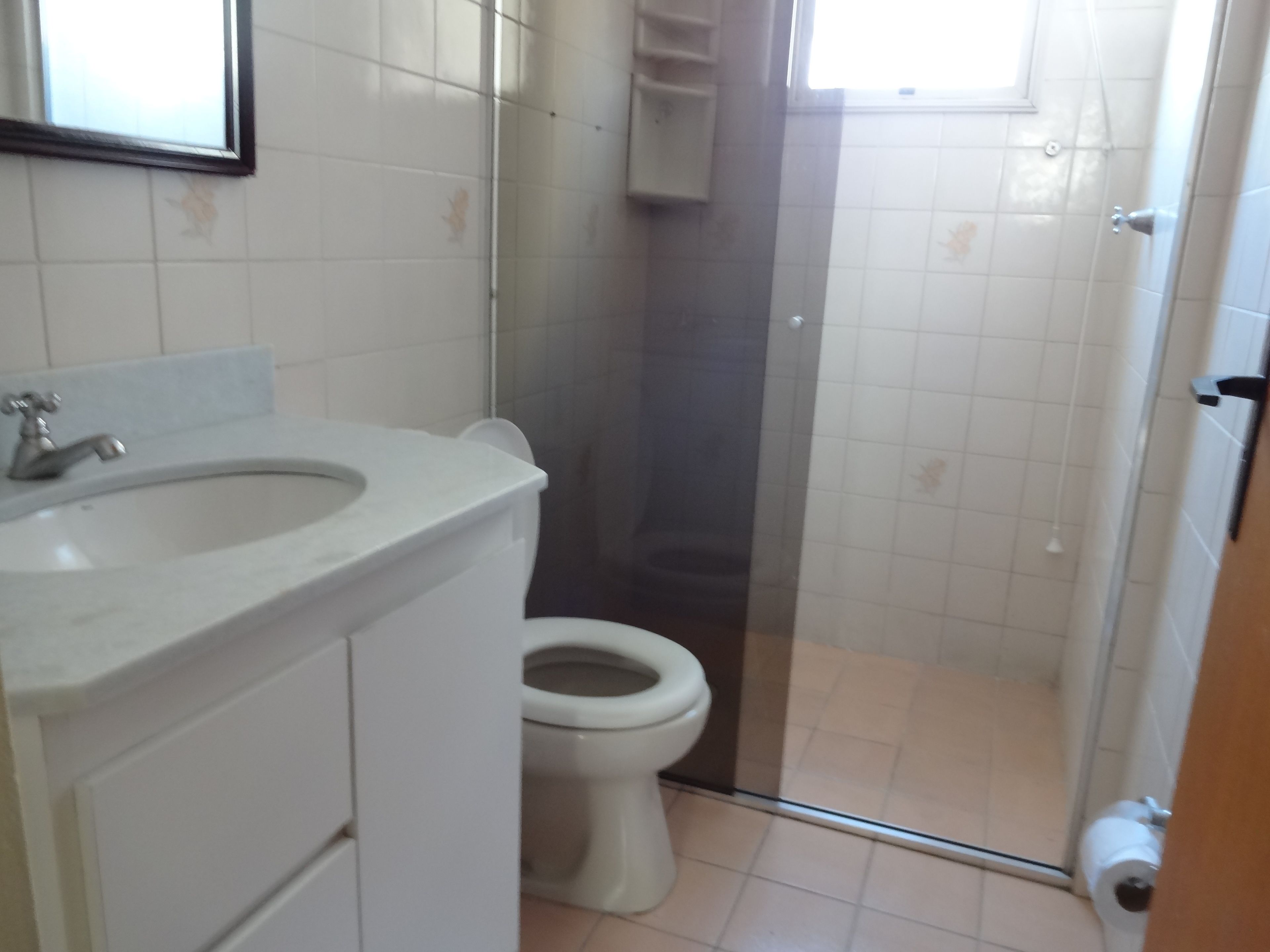 A bathroom with a sink, toilet, and shower area.