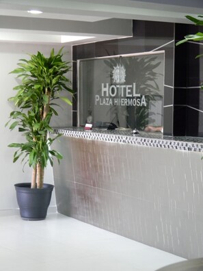Una mesa de recepción con un letrero que dice "HOTEL Plaza Hiermosa".