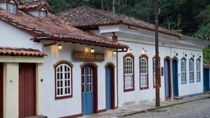 Un bâtiment doté d’un toit recouvert de tuiles, de nombreuses portes et de fenêtres ornées de cadres décoratifs.