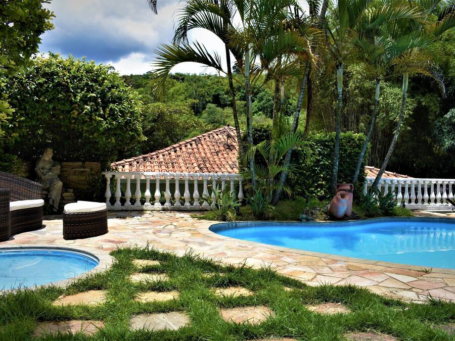 Een buitenzwembad, ligstoelen bij het zwembad