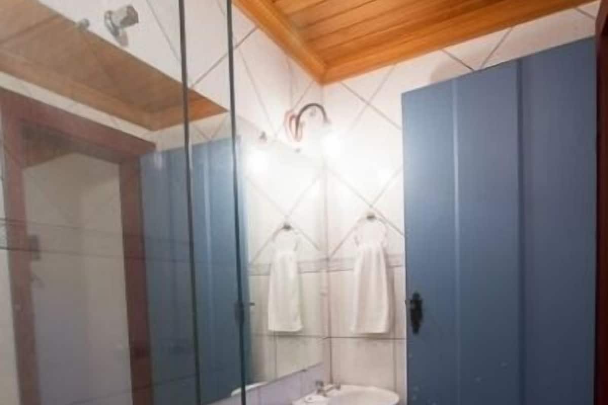 A bathroom with a toilet, sink, and mirror.