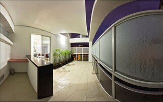 Un interior moderno con un mostrador central, una escalera y una pared de vidrio.