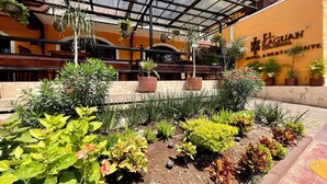 A hotel with a covered outdoor area featuring potted plants and a clear view of the building's exterior.