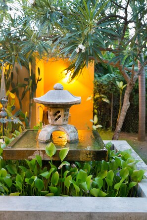 A traditional stone lantern with a water feature in a garden setting. - Casa de Amistad (Vieques)