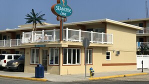 A building with a sign for 'Seahorse Inn' and a balcony with white railings. - Seahorse Inn (Wildwood)