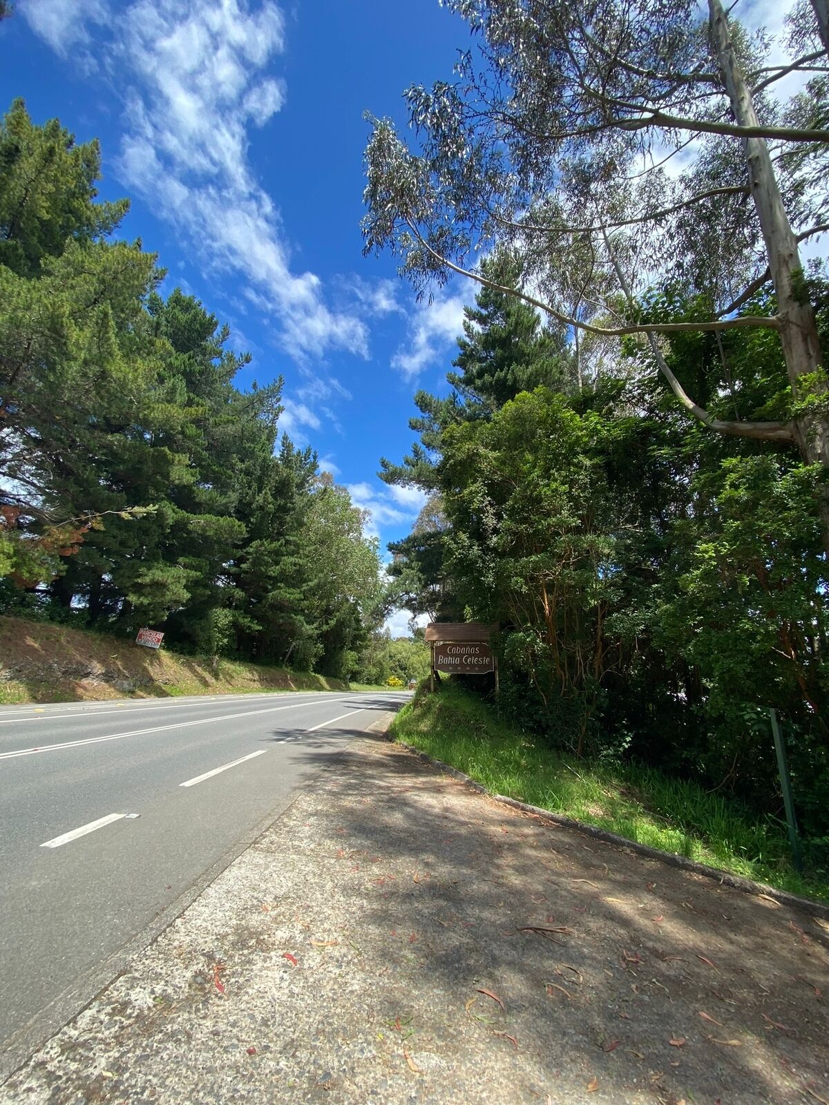 A road with a sign reading "Cabañas Bahia Celeste".