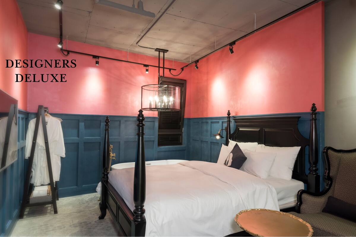 A room with a four-poster bed, a chandelier, and a blue and red color scheme.
