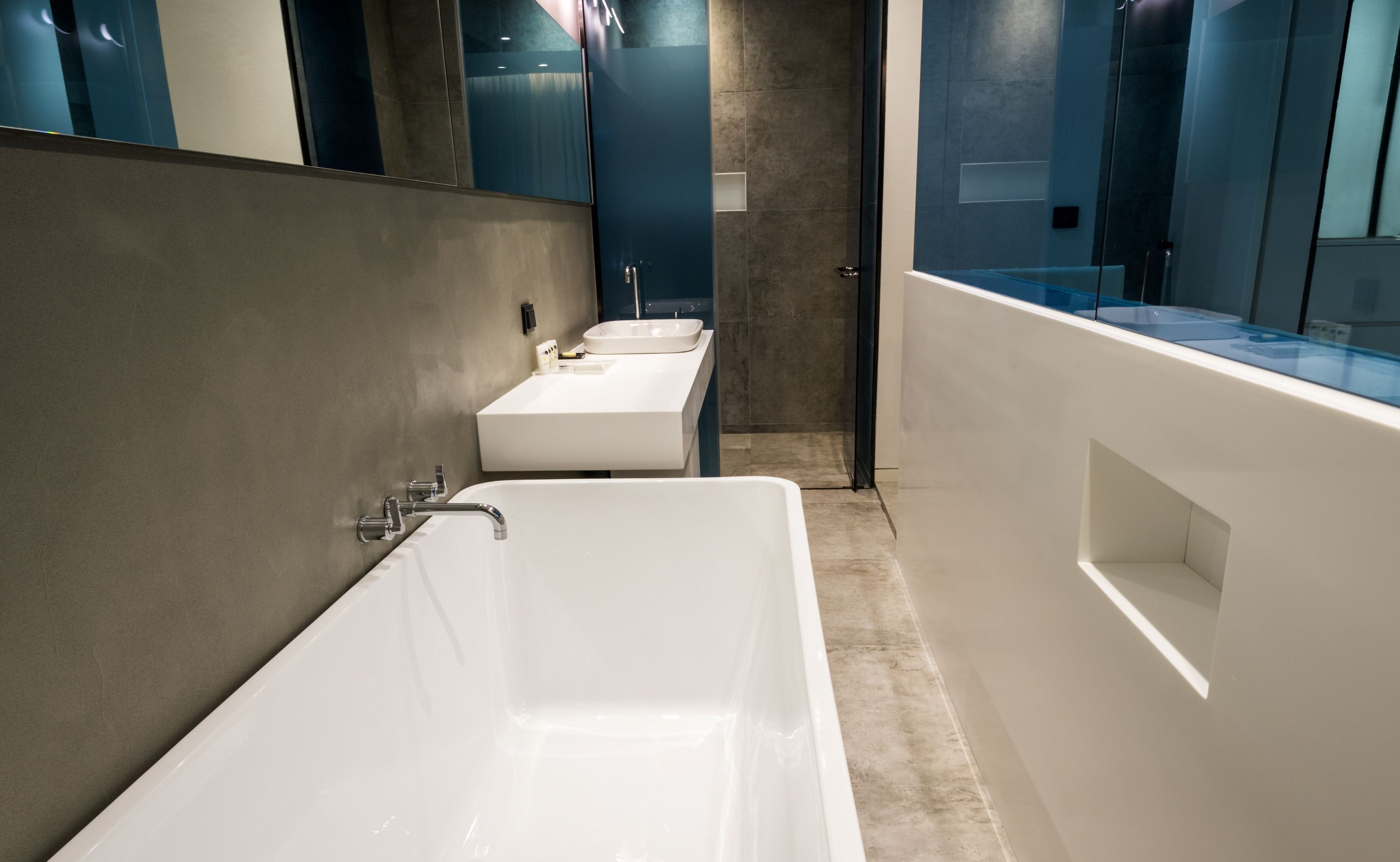 A modern bathroom with a large bathtub, two sinks, and a glass shower enclosure.