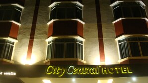 Exterior do Hotel City Central, com letreiros iluminados e fachada simétrica.