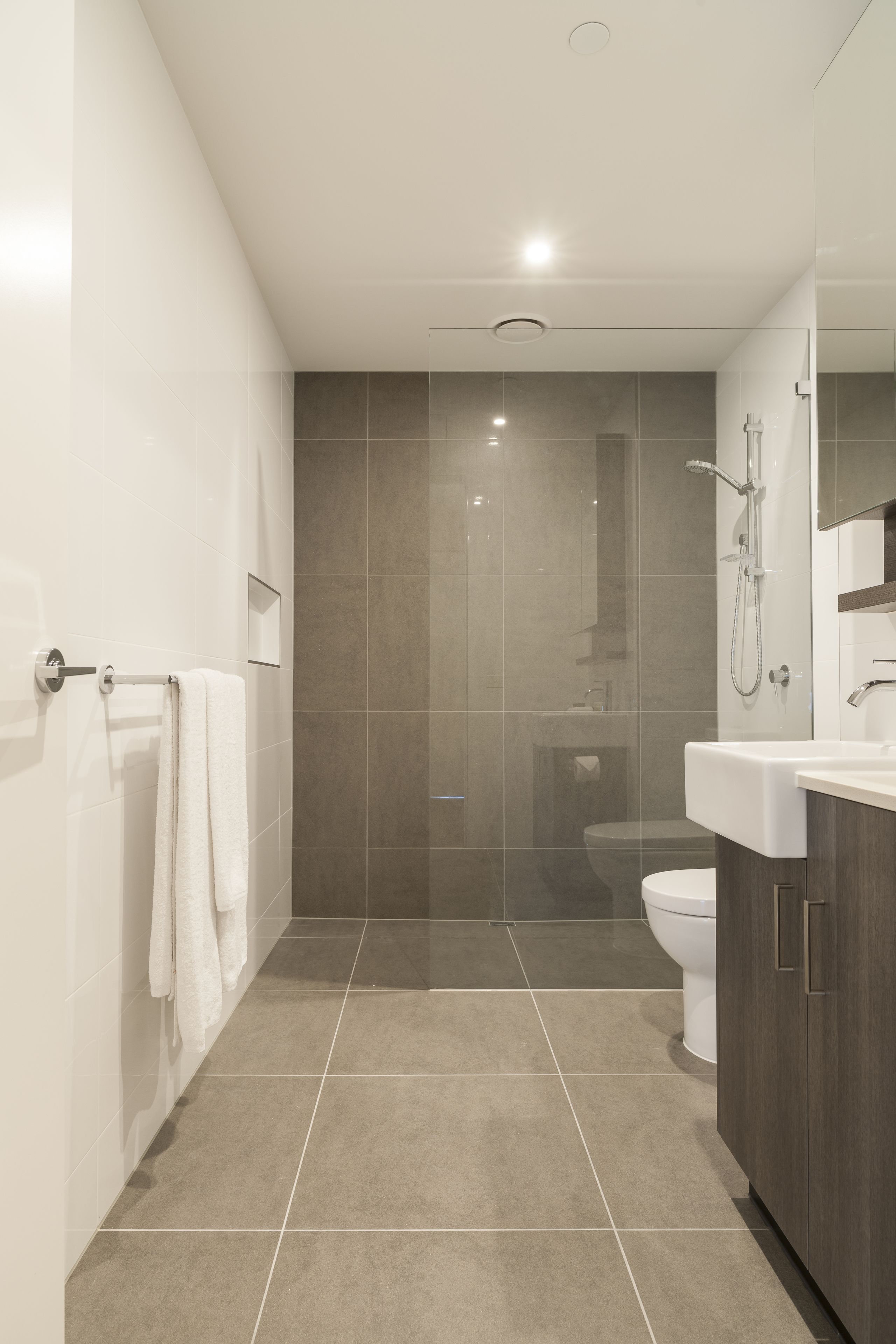 Un baño moderno con ducha, inodoro y lavamanos.