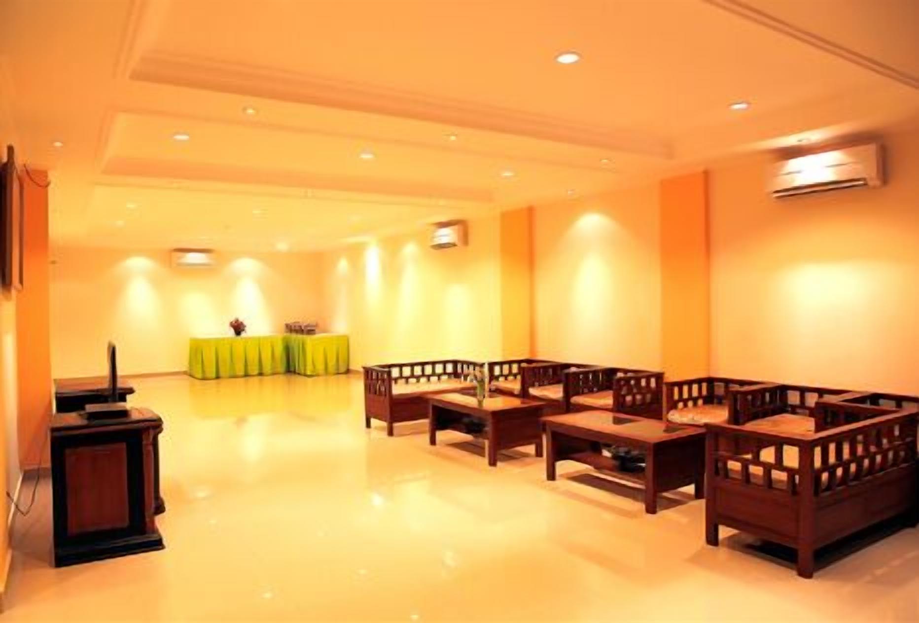 A spacious room with a long table and several wooden chairs arranged for seating.