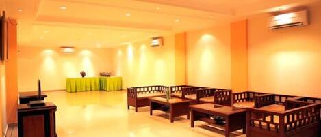 A spacious room with a long table and several wooden chairs arranged for seating.