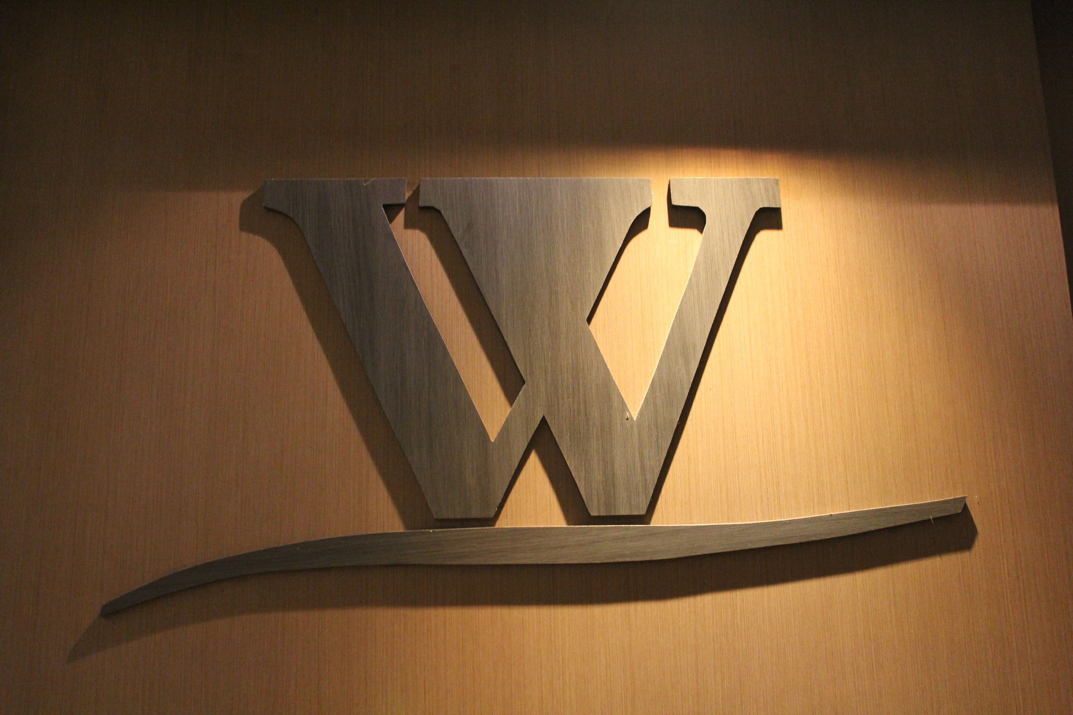 A wooden wall with a large, stylized letter 'W' mounted on it.