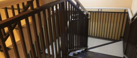 A staircase with wooden handrails and black metal railings.