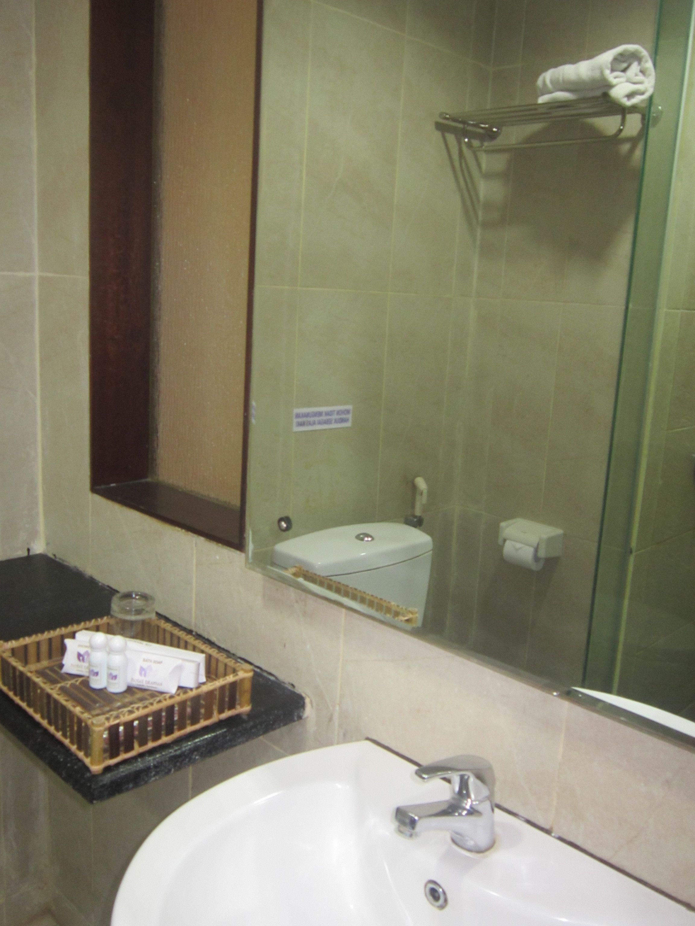 Un baño con lavamanos blanco, cabina de ducha de vidrio y un perchero para toallas.