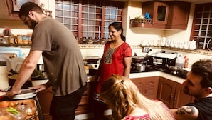 Una cocina con estufa, ollas y una persona cocinando.